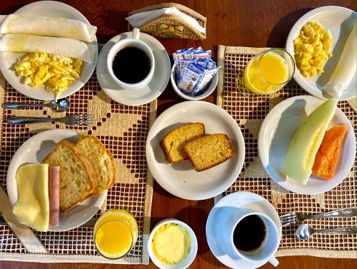 - une table avec des assiettes de produits pour le petit-déjeuner et des tasses de café dans l'établissement Le Marin Hotel Boutique, à Atins