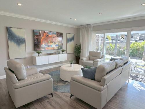 a living room with white furniture and a large window at Disneyland Paradise 6 BedRoom 4 Bathroom Pool Spa Games in Anaheim