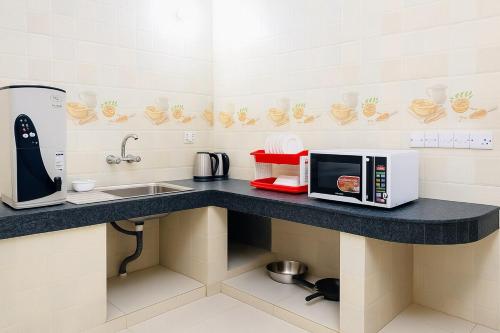 a kitchen with a counter top with a microwave at Dhaka Furnished Apartment in Gulshan in Dhaka