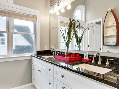 a bathroom with two sinks and a large mirror at Oceanfront Dream Home Spa Pool Pet Friendly in North Topsail Beach