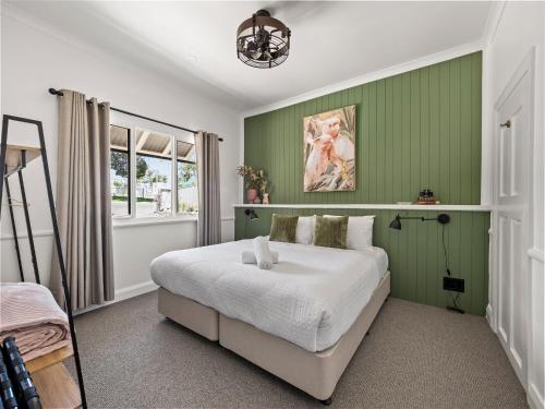 a bedroom with green walls and a large bed at Whitehouse Cottage - Margaret River in Margaret River Town