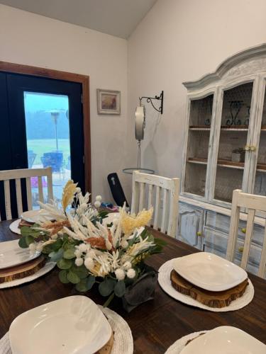 una mesa de comedor con platos y flores. en Cedar cross cabin, 