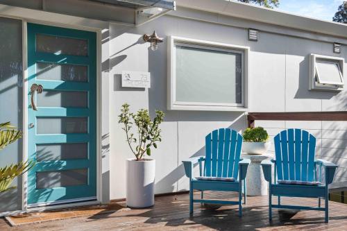 two blue chairs sitting next to a table on a patio at The Chill - Your Dreamy Waterfront Escape in Sanctuary Point