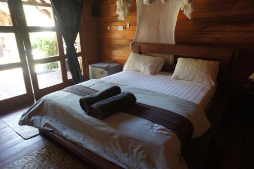 a bedroom with a large bed with a large window at karma villa gili in Gili Trawangan