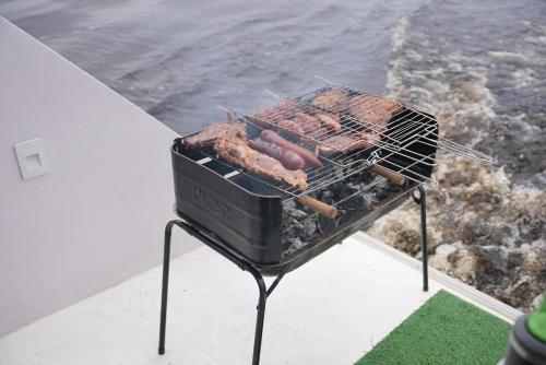 een grill met hotdogs en worstjes erop bij Iate AmazonHunter in Manaus