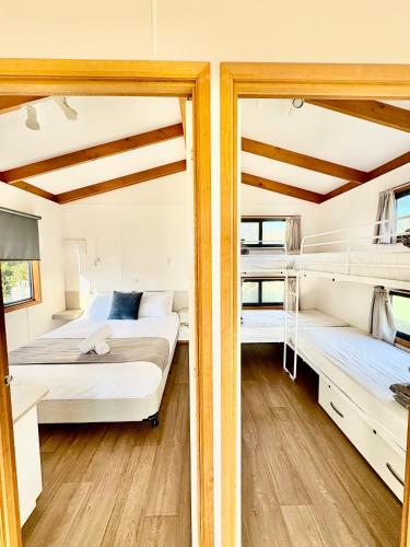 two beds in a room with two bunk beds at BIG4 Long Jetty Caravan Park in Port Welshpool