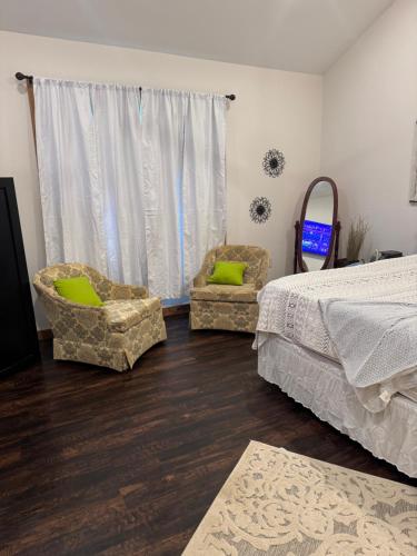 1 dormitorio con 2 sillas, 1 cama y 1 ventana en Cedar cross cabin, 