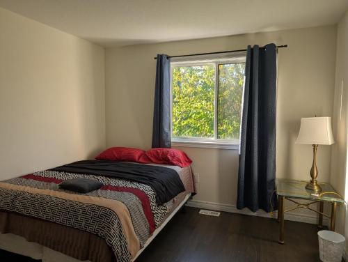 a bedroom with a bed and a window at Modern 3BR Home Near Niagara Falls & Welland Canal in Welland