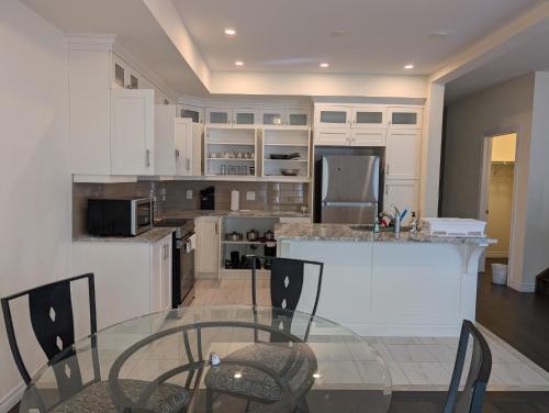 a kitchen with a glass table and a counter at Modern 3BR Home Near Niagara Falls & Welland Canal in Welland