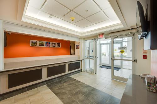 an empty lobby with an orange accent wall at Motel 6-Brampton, ON - Toronto in Brampton