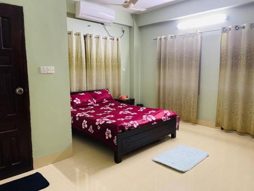 a bedroom with a bed with red sheets and curtains at Bashundhara Luxury 3BR Apartment Near Evercare in Dhaka