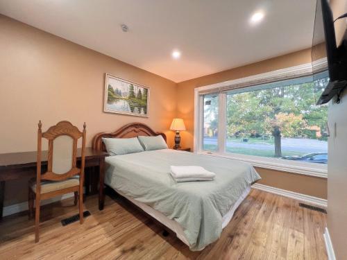 a bedroom with a bed and a desk and a window at Spacious Rooms with Bath Near Wonderland & Vaughan Mills Mall in Vaughan