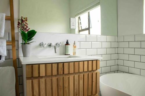 ein Badezimmer mit Waschbecken und Badewanne in der Unterkunft 1 Waterkant Luxury Renovated 3 Bedroom House in De Kelders