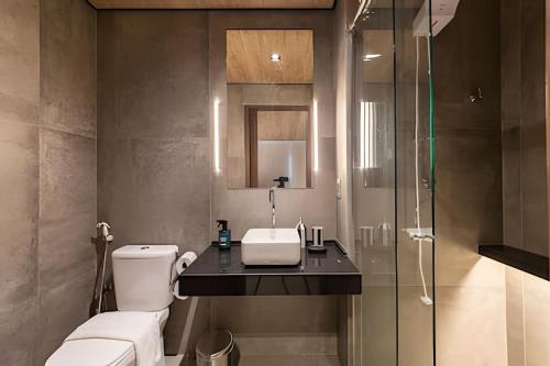 a bathroom with a toilet and a sink and a shower at Edifício New Time, Seu Refugio a Beira Mar de Pajuçara in Maceió