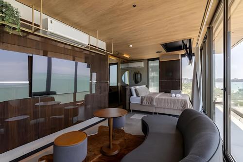 a room with a bed and a couch and some windows at Edifício New Time, Seu Refugio a Beira Mar de Pajuçara in Maceió