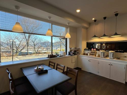 a kitchen with a table and chairs and a window at Fuji Premium Hotel in Fujiyoshida