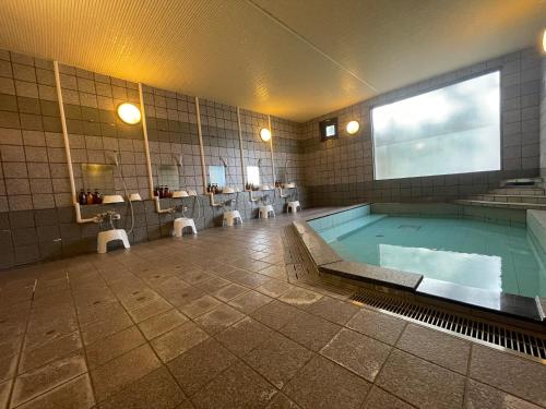 a bathroom with a large swimming pool in the middle at Fuji Premium Hotel in Fujiyoshida