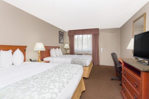 a hotel room with two beds and a flat screen tv at Days Inn by Wyndham St Augustine/Historic Downtown in St. Augustine