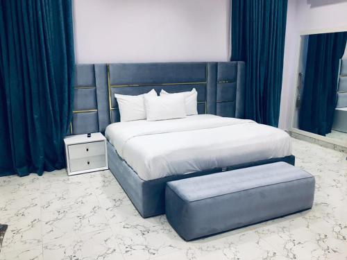 Sagisaにある5bedroom duplexのキングサイズのベッドとオットマンが横に置かれた寝室