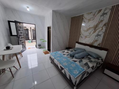 a bedroom with a bed with blue pillows and a table at YouYouKe Papillon in Cilauteureun