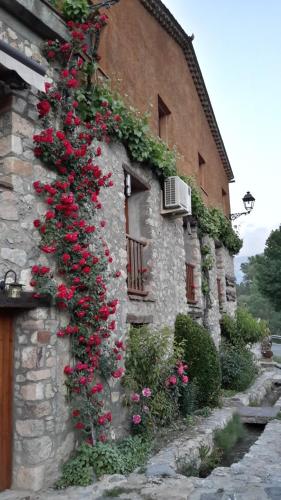 a building with flowers on the side of it at Casa Rural Molí de Fòrnols in Fornols