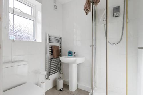 a white bathroom with a sink and a shower at Awesome Games Room House! EMA Donington Park, with FREE parking in Kegworth