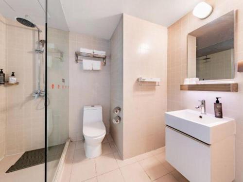a bathroom with a toilet and a sink and a shower at Jinjiang Inn Select Hohhot Chengjisihan Square Metro Station in Hohhot