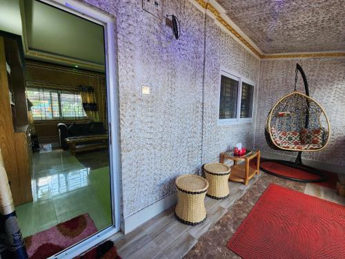 a room with two tables and two stools and a window at Mukta Nagar Resort in Pitua