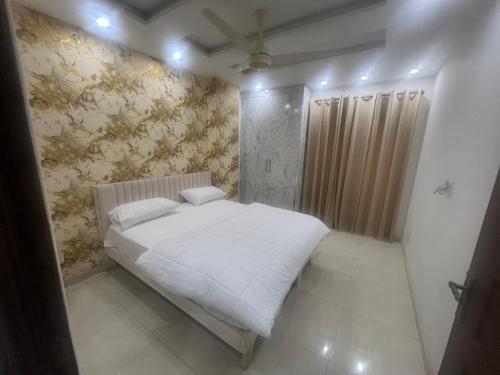 a bedroom with a white bed in a room at Royal BNB Two BedRoom Luxury Apartment in Lahore