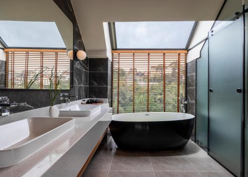 a bathroom with two sinks and a large tub at Là Yên Retreat in Ấp Ða Lợi