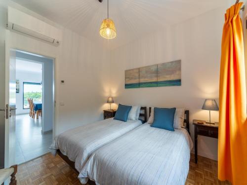 Un dormitorio con una cama grande con almohadas azules. en Casa O Sonho near Faro with private pool, en Santa Bárbara de Nexe