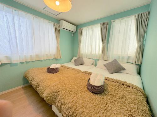2 letti in una camera con pareti e finestre blu di THE FEEL ONNA 2 / Vacation STAY 18241 a Onna