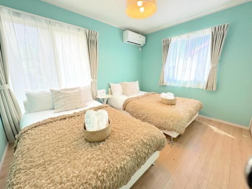 two beds in a room with blue walls at THE FEEL ONNA 2 / Vacation STAY 18771 in Onna