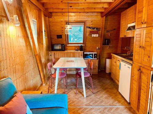 a kitchen with a table and chairs in a cabin at Le Chalet Cosy - 2 chambres - MÉNAGE INCLUS in Puyvalador