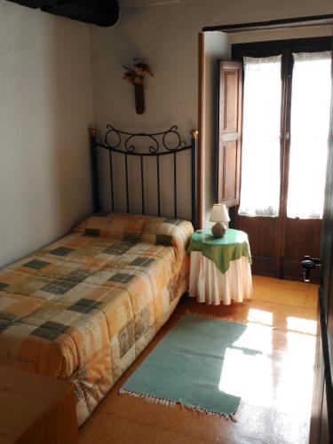 a bedroom with a bed and a table and a window at Casa Turpesa in Peñalba de Santiago