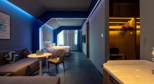 una stanza con un letto, un tavolo e un divano di GreenTree Eastern Hotel Nanning Wuxiang Hangyang City a Nanning
