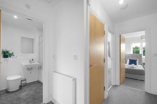 a bathroom with a sink and a toilet in a room at Spacious 6 Bedroom 2 Bath Serviced House with Parking in Denton Way in Slough