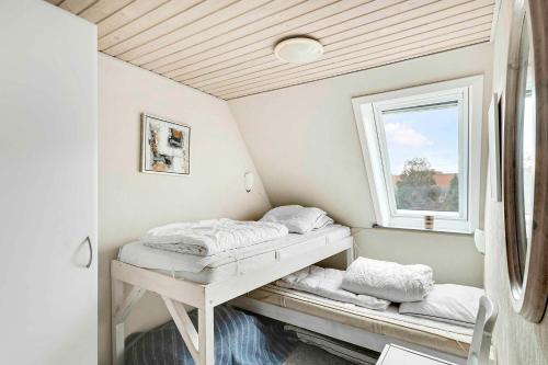 two beds in a room with a window at Spacious House With Sea Views From All Rooms in Rønne