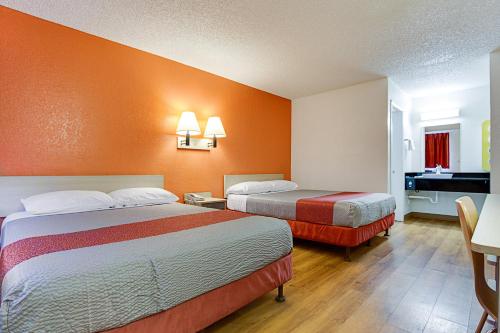a hotel room with two beds with orange walls at Motel 6-Tempe, AZ - Scottsdale South in Tempe