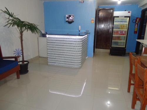 a room with a drink machine and a blue wall at Pousada Damasco in Brasília