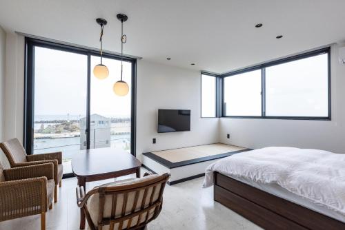 a bedroom with a bed and a desk and a table at Cottage TAIZA in Kyotango