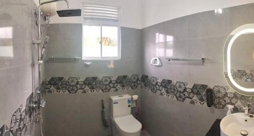 une salle de bains avec toilettes et lavabo dans l'établissement Rose Apartment, à Kadawata