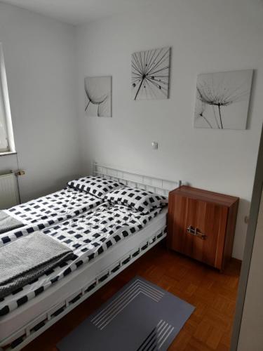 a bedroom with a bed and two pictures on the wall at Designer apartment in nature in Vojnik