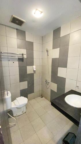 a bathroom with a toilet and a sink at Saka Hotel Medan in Sunggal