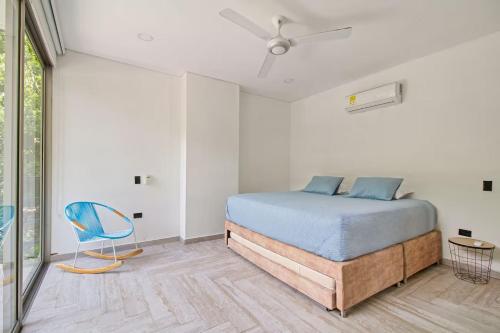 a bedroom with a bed and a blue chair at Casa BaruGrande in Cartagena de Indias