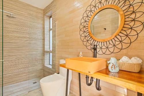 a bathroom with a sink and a mirror and a toilet at Casa BaruGrande in Cartagena de Indias