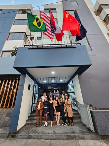 a group of people standing in front of a building with flags at Hotel Naciones Unidas in Lima