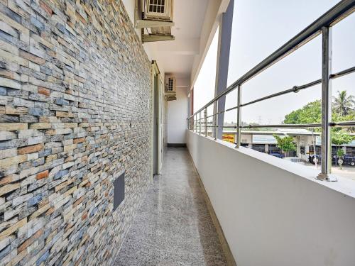 a hallway of a building with a brick wall at Hotel O AVR residency in Vengal