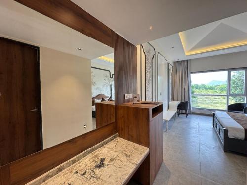 a hotel room with a large mirror and a bedroom at Nazaara Hills Retreat in Thūr