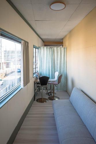 a room with a bed and a desk and a window at Your Space Capsule Hotel Fuji Station in Fuji